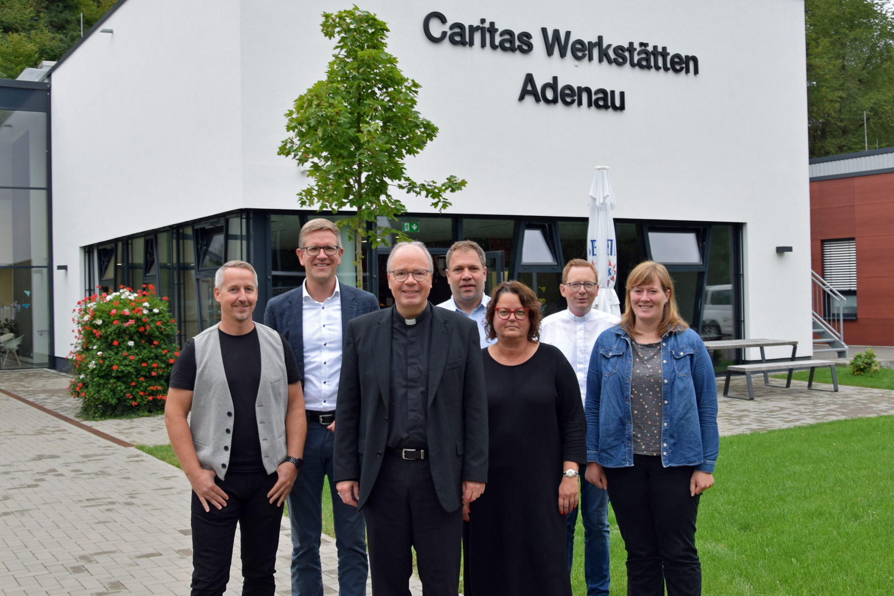 Vor den Caritas Werkstätten Adenau (v.li.): Martin Retterath (Fachdienst), Thomas Buckler, Bischof Ackermann, Johannes Haubrich, Britta Lott, Florian Dienhart, Anita Nohner