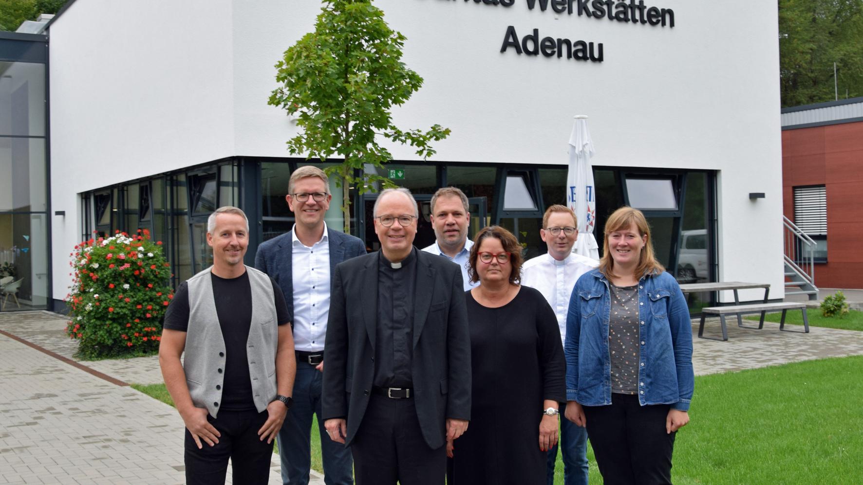 Vor den Caritas Werkstätten Adenau (v.li.): Martin Retterath (Fachdienst), Thomas Buckler, Bischof Ackermann, Johannes Haubrich, Britta Lott, Florian Dienhart, Anita Nohner