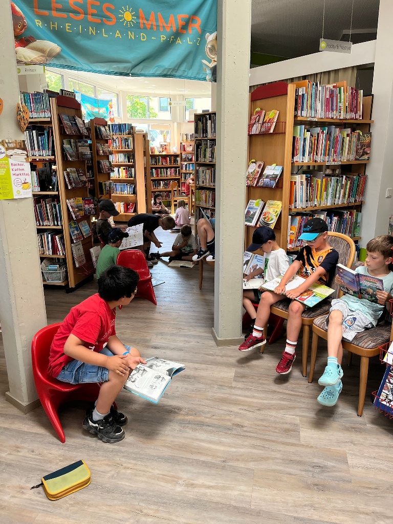 Kinder schmökern in der Bücherei