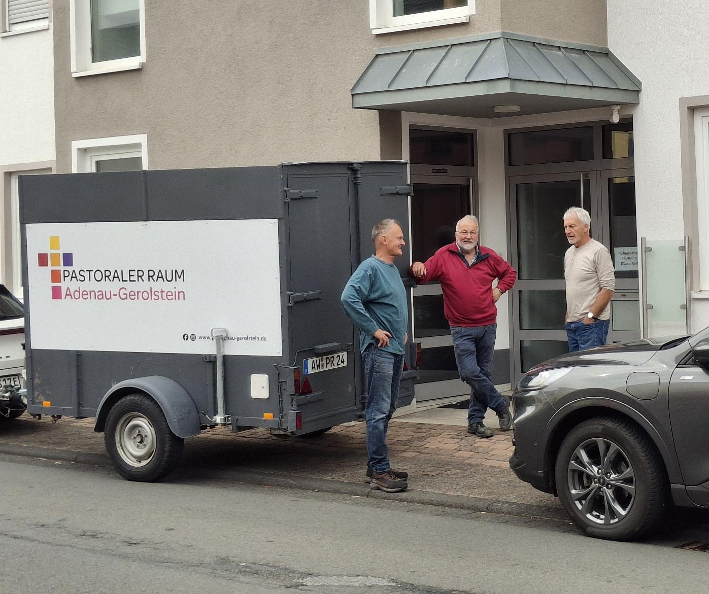 Die ehrenamtlichen Umzugshelfer Manfred Hellmann, Clemens Heintges und Günther Möller vor dem neuen Pfarrbüro in Lissendorf