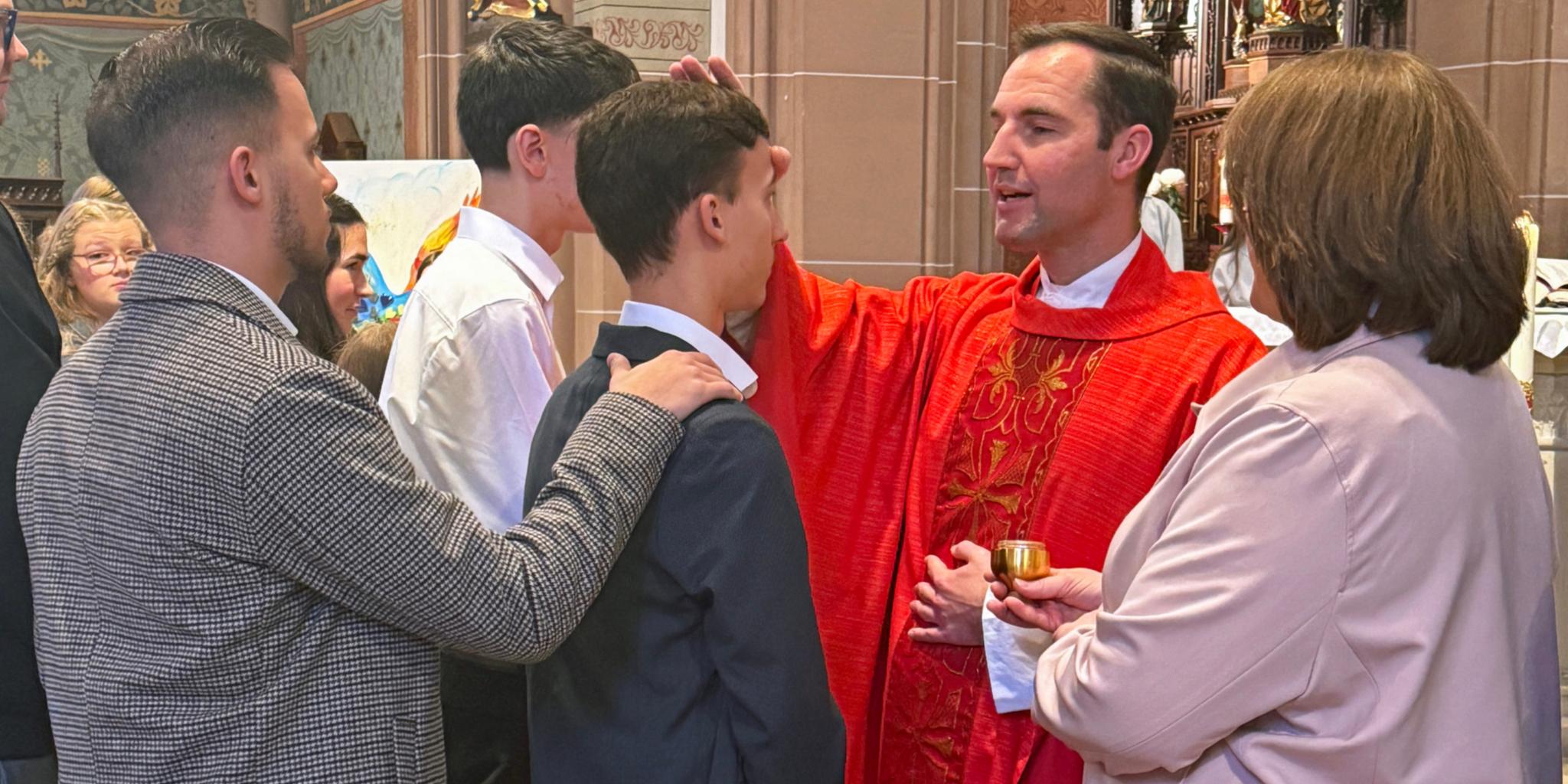 Peter Zillgen firmt Jugendlichen mit dem Chrisam-Öl