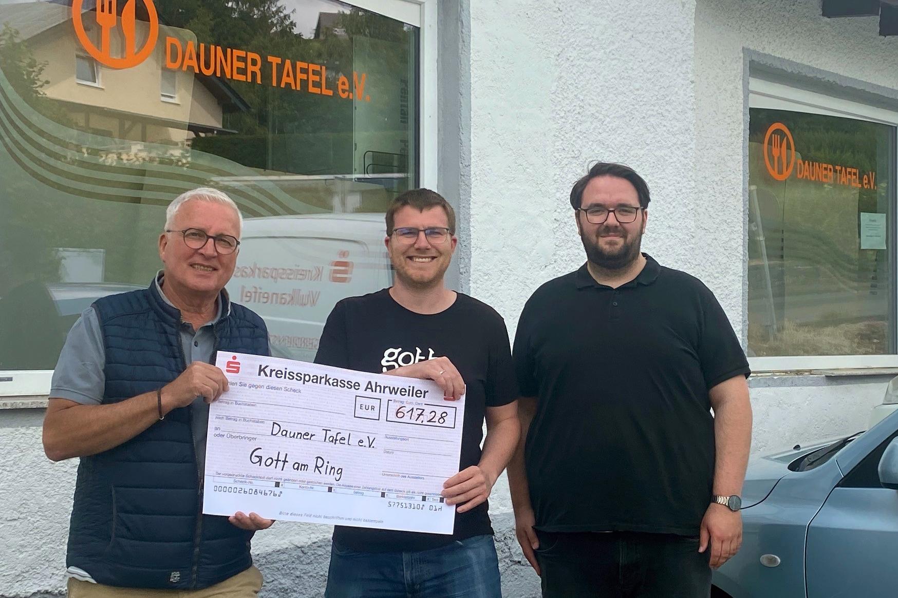 Christian Bauer (links) und Jörg Freitag (rechts) freuen sich über die Spende, die Philipp Hein vom Gott-am-Ring-Zelt der Dauner Tafel überreicht.