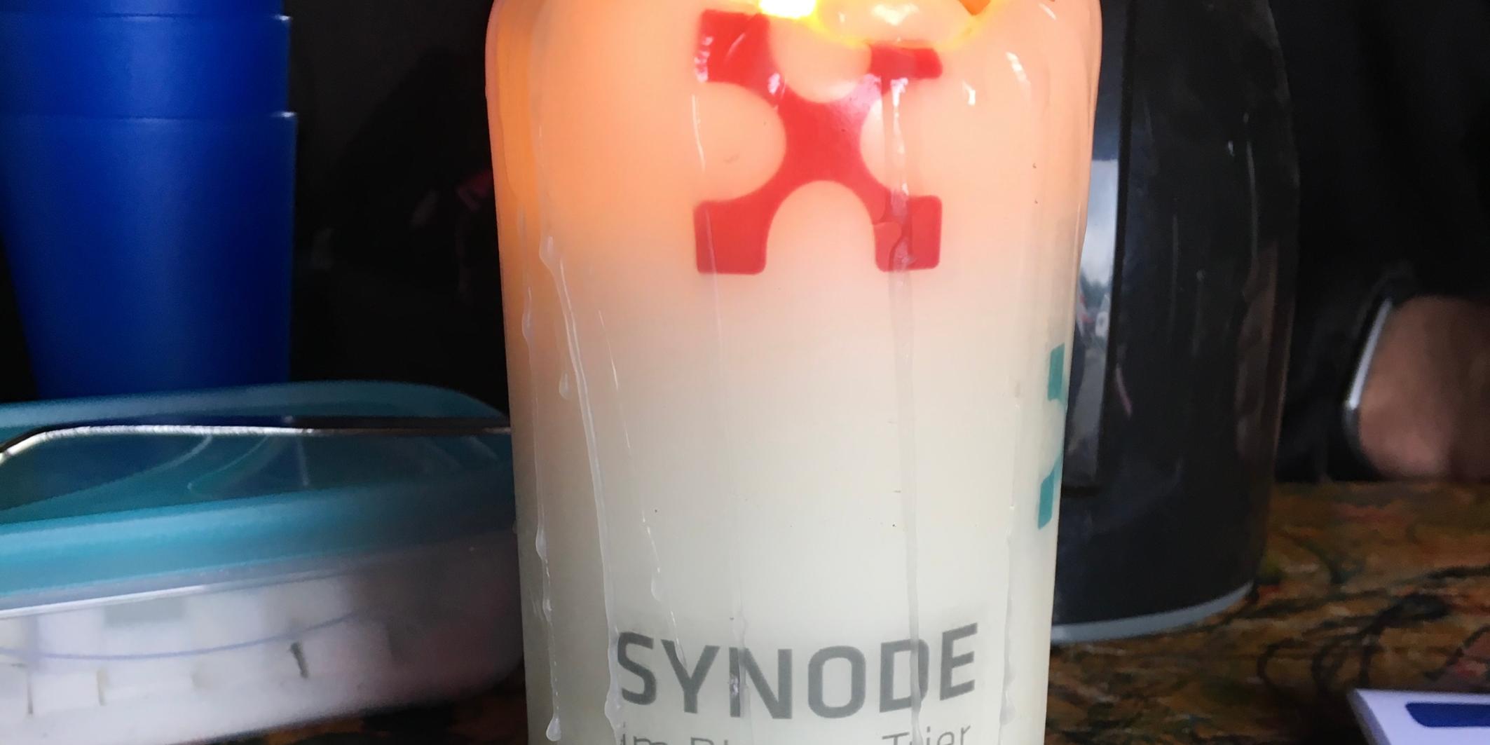 Eine brennende Kerze mit der Aufschrift 'Synode'.