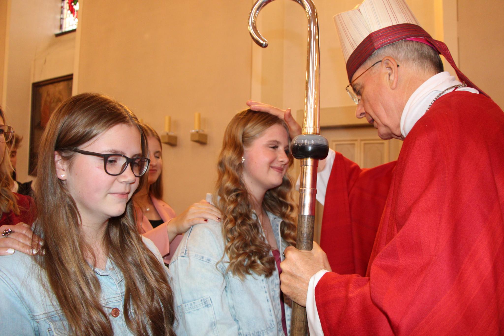 Weihbischof Peters spendet einer jungen Christin das Firmsakrament.